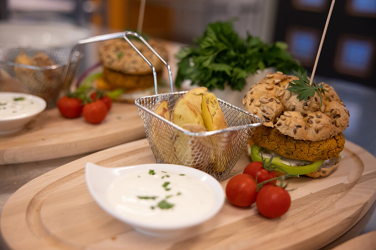 Burger mit Wedges und Sauce auf Tablett