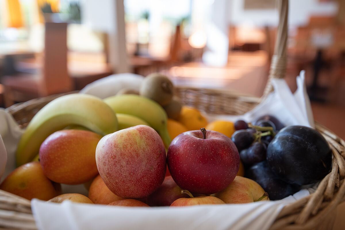 gefüllter Obstkorb mit frischen Äpfeln, Bananen und Mandarinen