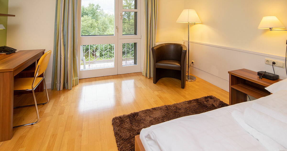 Einzelzimmer mit Bett, Tisch & Stuhl